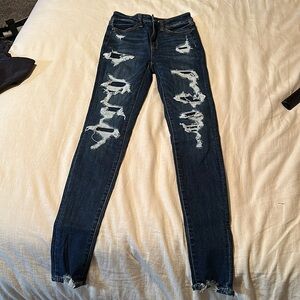 American Eagle skinny jeans with patched holes.